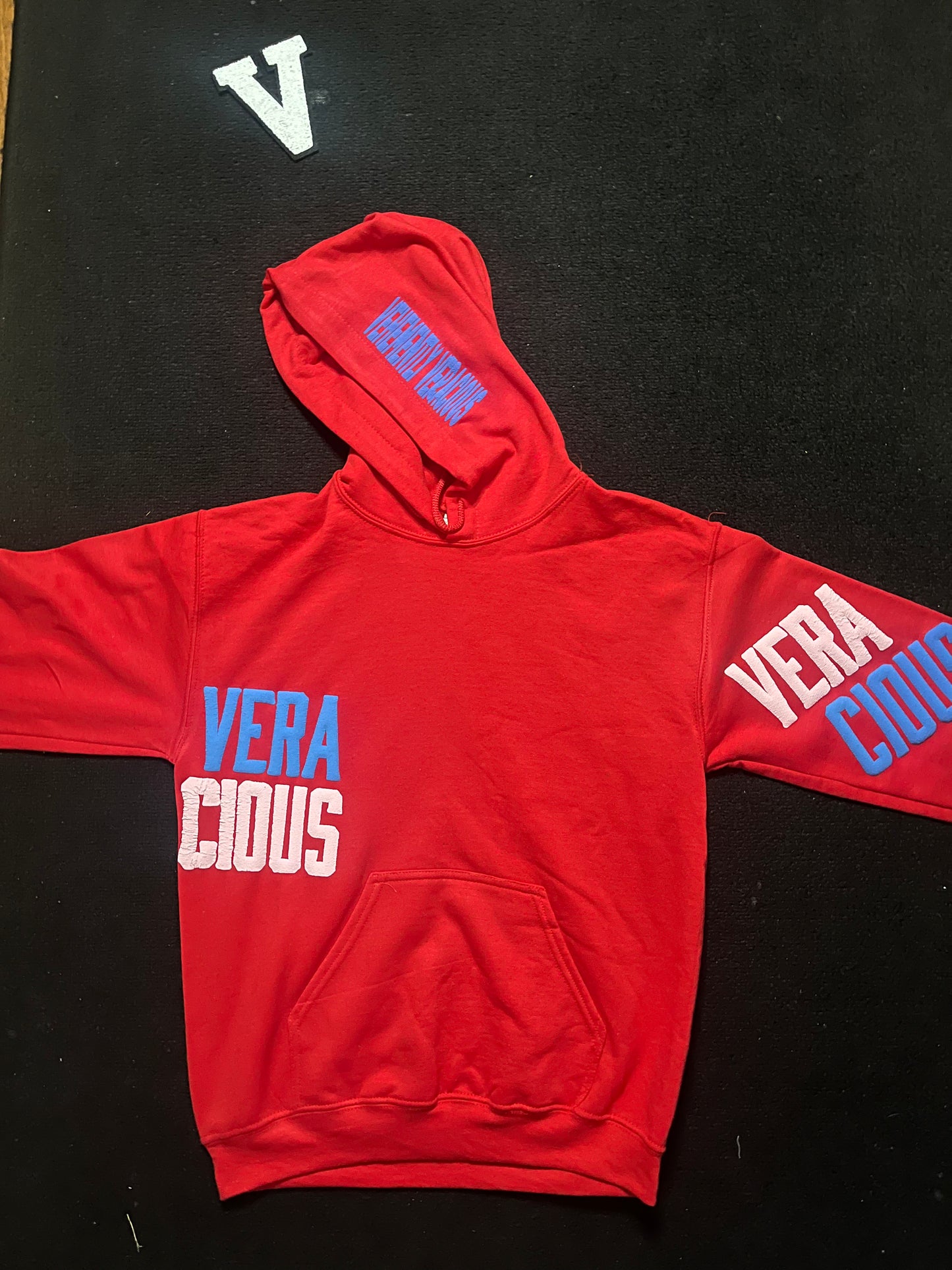 Red hoodie with 'VERA CIVICUS' text on a black background
