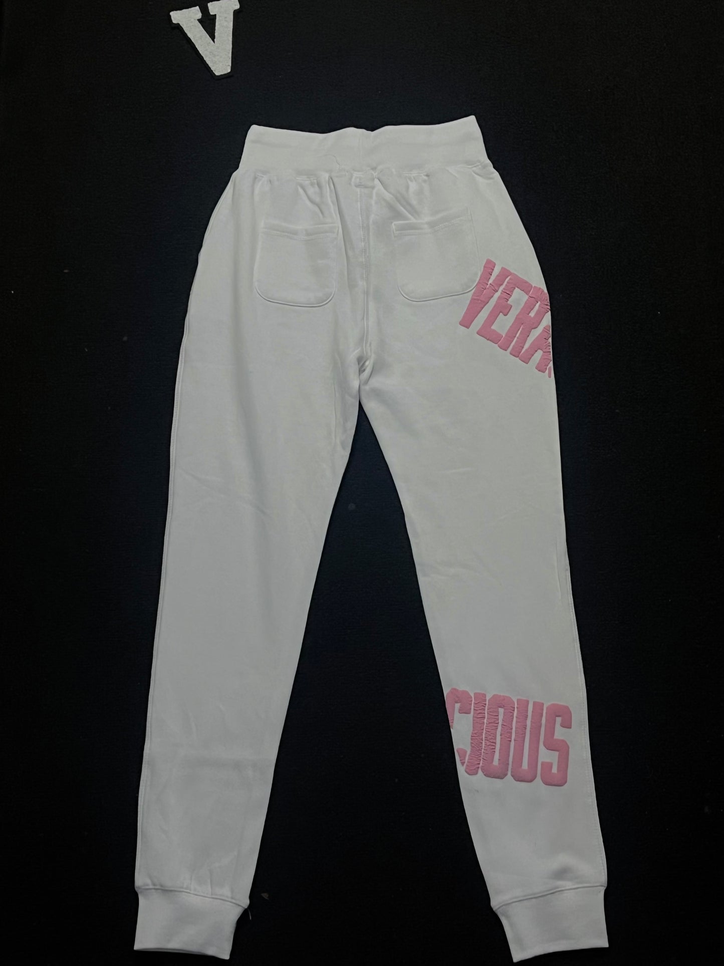 white sweatpants with pink text on a black background