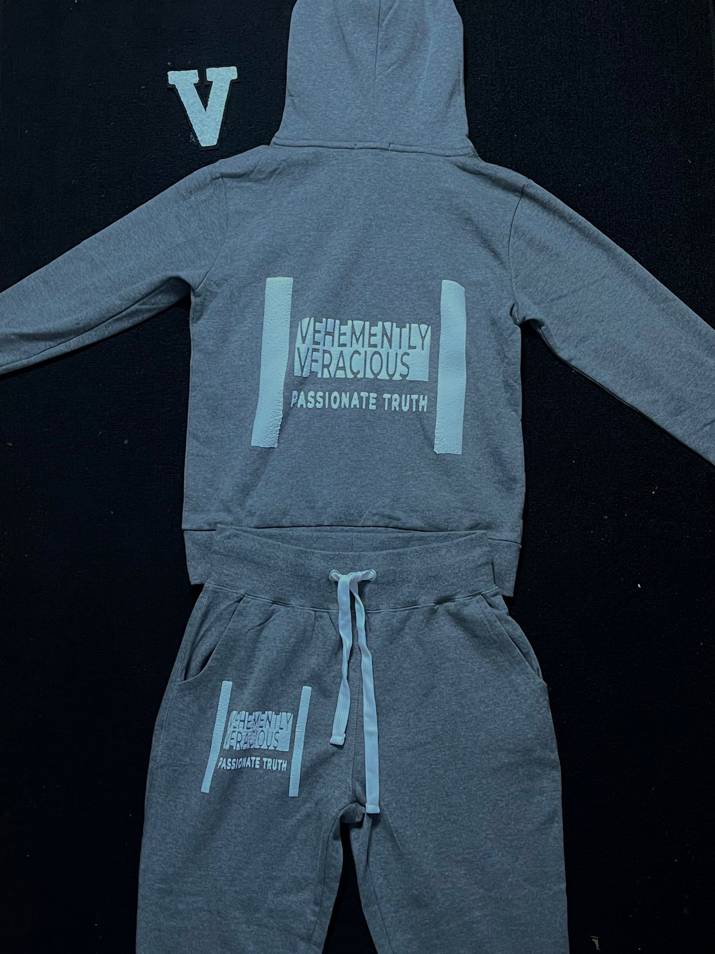 Gray hoodie and pants set with text on a black background