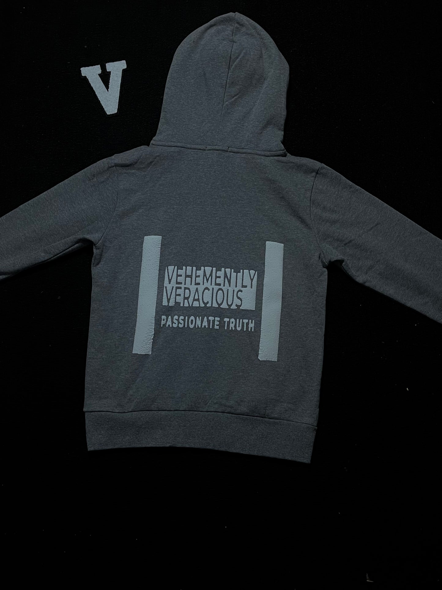 Gray hoodie with text on the back against a black background