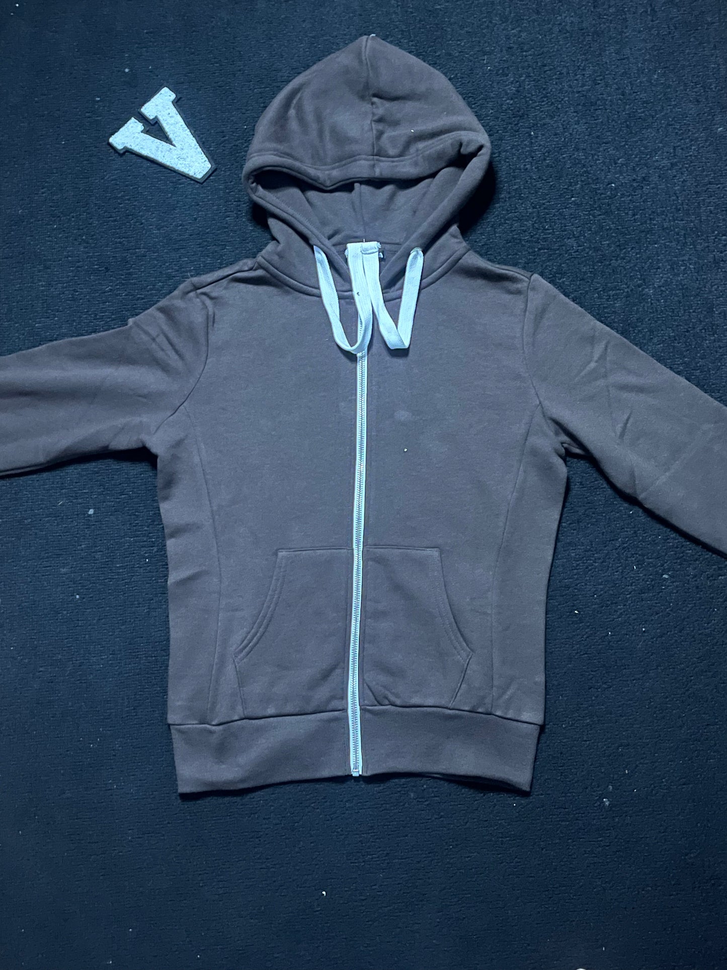 Deep chocolate hoodie with a white zipper on a dark blue background
