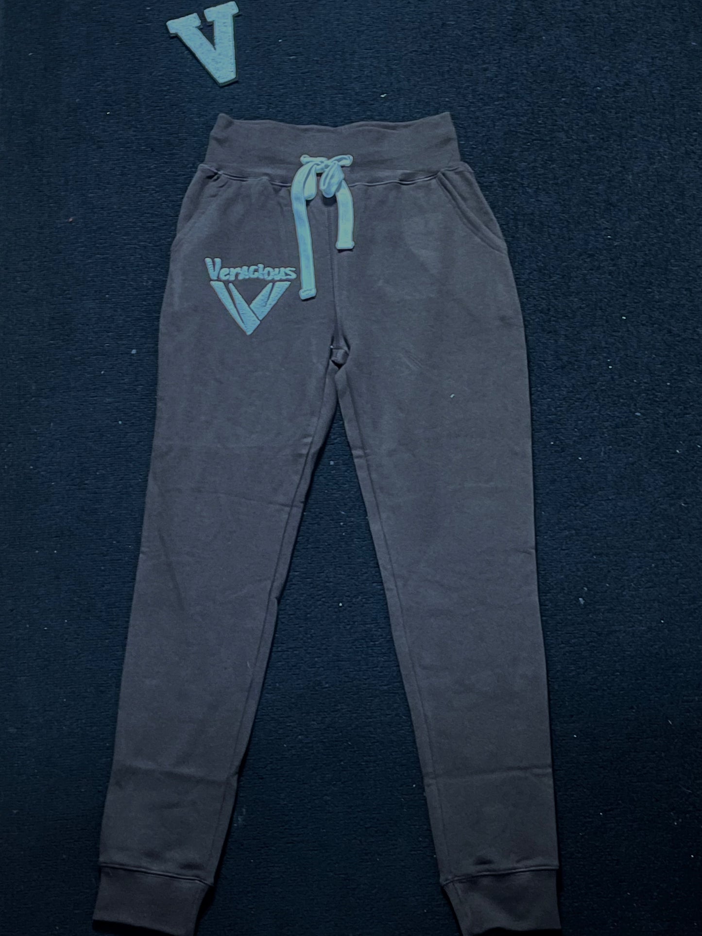 deep chocolate sweatpants with a brand logo on a dark background