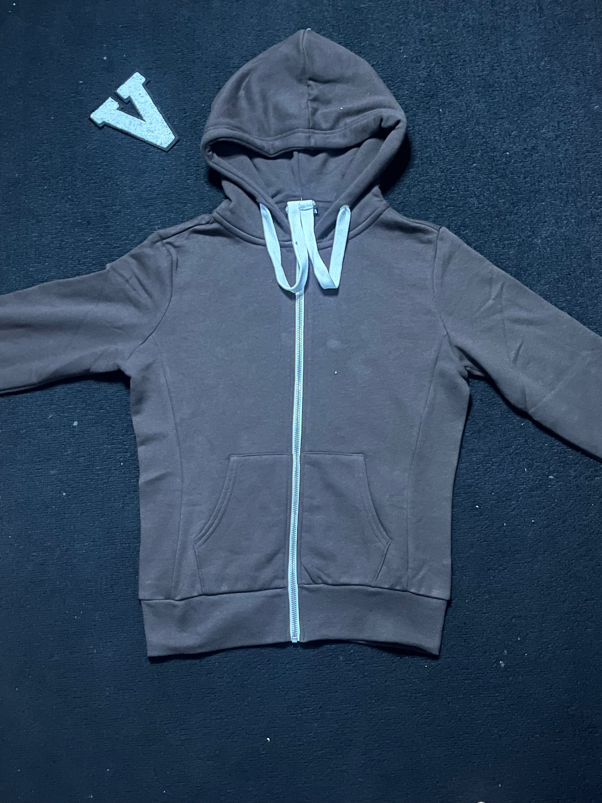 Deep chocolate hoodie with a white zipper on a dark blue background
