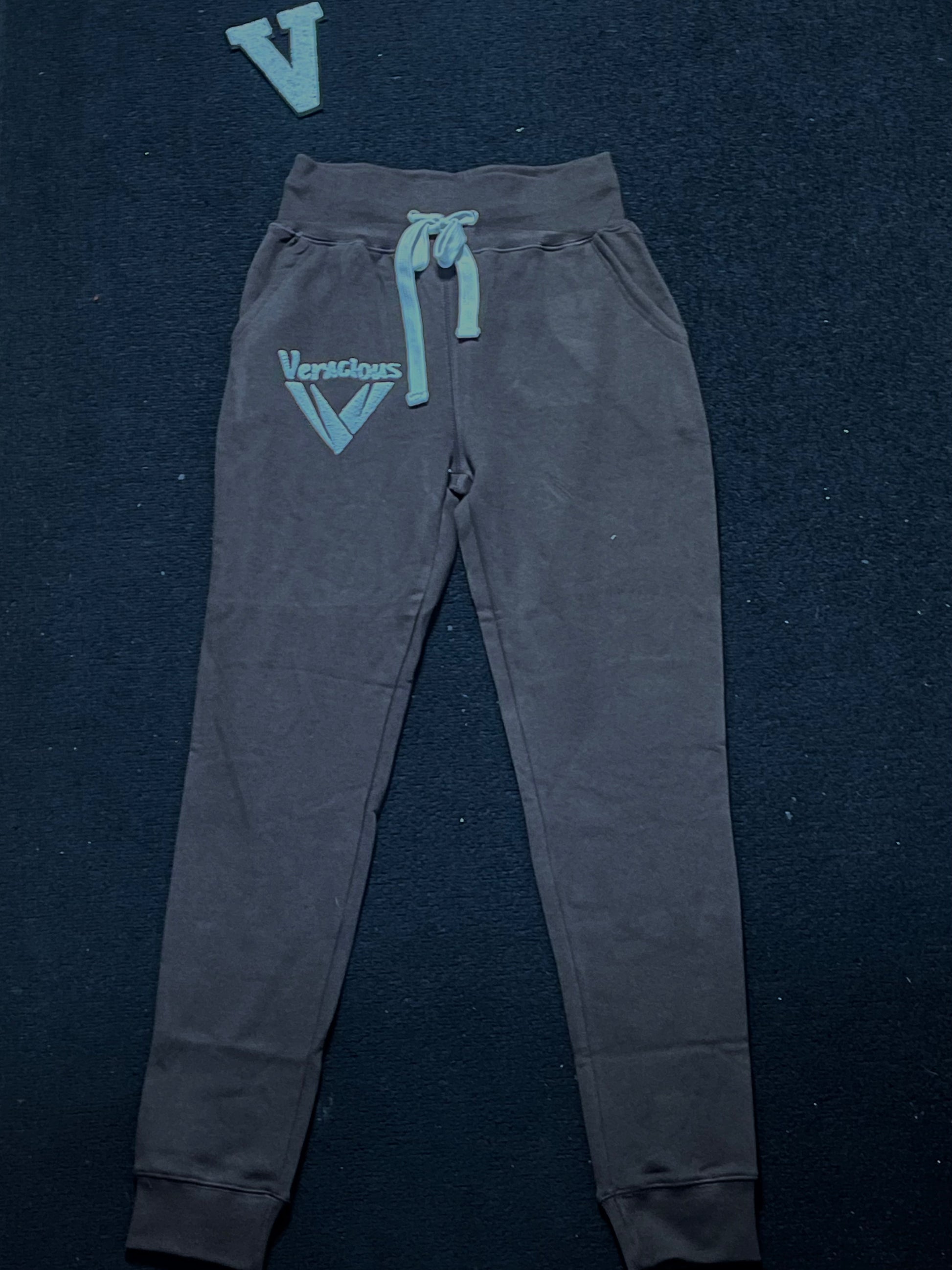 deep chocolate sweatpants with a brand logo on a dark background